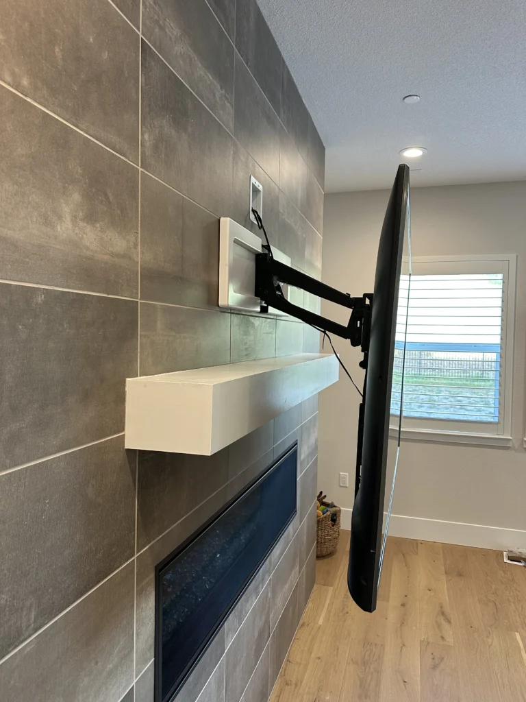 MantelMount pull-down TV mount extended over a tiled fireplace