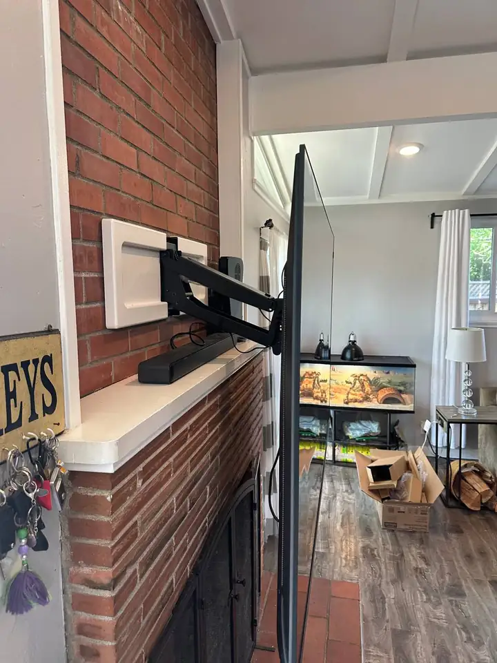 MantelMount arm extended over a brick fireplace mantel